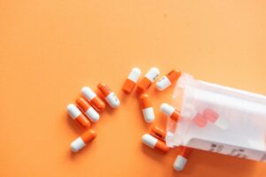 Pills spilling out of a pillbox on its side.