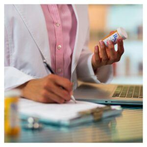 pharmacist holding pill bottle and writing prescriptions